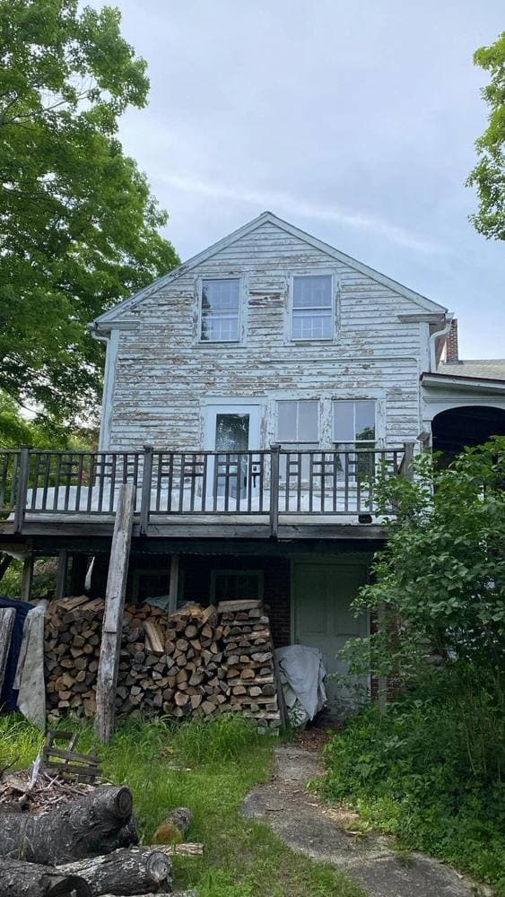 Exterior of a New England home being painted on a clear late-summer afternoon