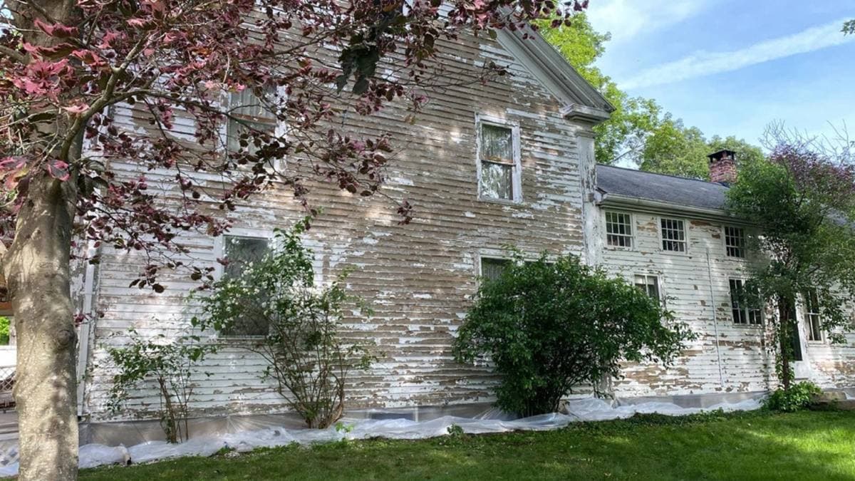 Weathered clapboard exterior of a New England home showing the effects of seasons